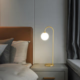 Minimalist Glass Globe Shade Curved Brass Table Lamp Image - 11