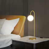 Minimalist Glass Globe Shade Curved Brass Table Lamp Image - 3